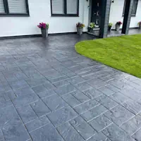 An employee of Wollongong Driveway Resurfacing working on a driveway that is having its concrete resurfaced.